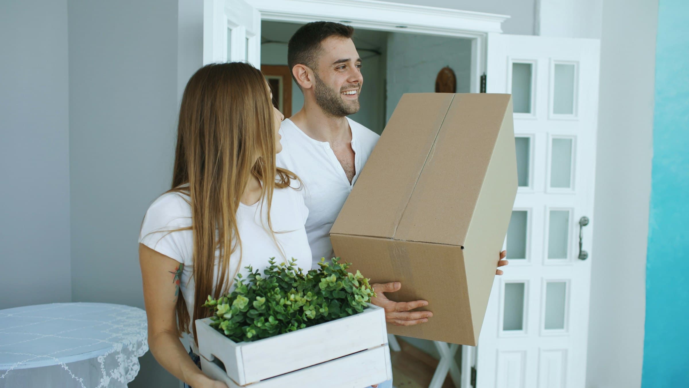 Paar trägt Umzugskartons in das neue Zuhause